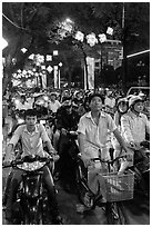 Street packed with motorbikes and bicycle riders at night. Ho Chi Minh City, Vietnam (black and white)