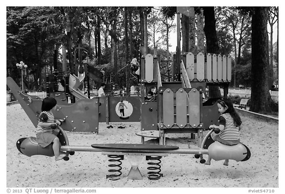 Girls with matching outfits on playground, Van Hoa Park. Ho Chi Minh City, Vietnam (black and white)