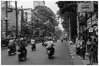 Motorbike traffic and pedestrians waiting for bus. Ho Chi Minh City, Vietnam ( black and white)