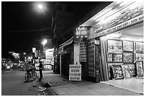 Stores selling pictures at night. Ho Chi Minh City, Vietnam (black and white)