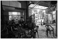 Communist party office and store selling images at night. Ho Chi Minh City, Vietnam (black and white)