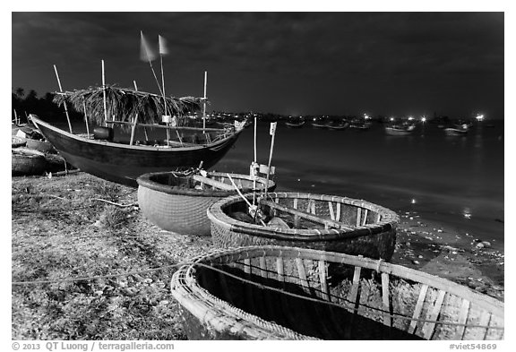 Coracle boats and fishing fleet at night. Mui Ne, Vietnam (black and white)