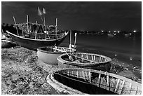 Coracle boats and fishing fleet at night. Mui Ne, Vietnam ( black and white)