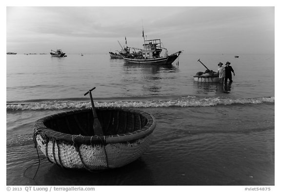 Coracle and fishing boats at dawn. Mui Ne, Vietnam (black and white)