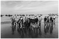 Women gather on beach to collect freshly caught fish. Mui Ne, Vietnam (black and white)