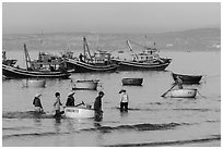 Fishermen use coracle boats to bring back catch from fishing boats. Mui Ne, Vietnam (black and white)