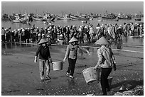 Women carrying baskets with shells. Mui Ne, Vietnam (black and white)