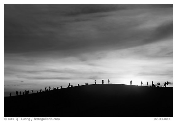 Tourists watching sunset from dune. Mui Ne, Vietnam (black and white)