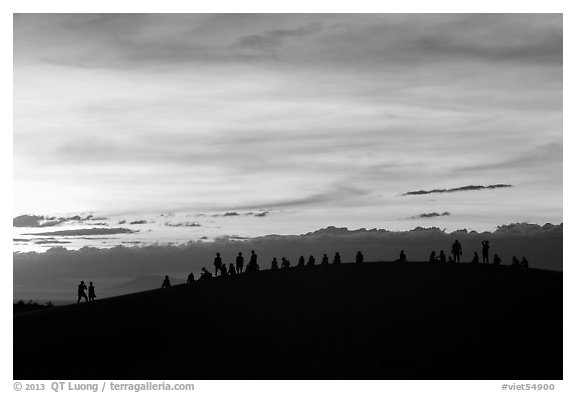 Tourists on dune ridge at sunset. Mui Ne, Vietnam (black and white)