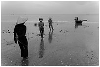 Fishermen pulling line onto beach. Mui Ne, Vietnam (black and white)