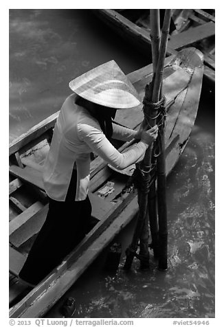 Woman in Ao Ba Ba holding from boat to bamboo poles. My Tho, Vietnam