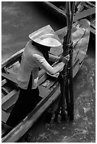 Woman in Ao Ba Ba holding from boat to bamboo poles. My Tho, Vietnam (black and white)