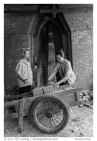 Workers loading bricks out of brick oven. Mekong Delta, Vietnam (black and white)