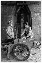 Workers loading bricks out of brick oven. Mekong Delta, Vietnam (black and white)