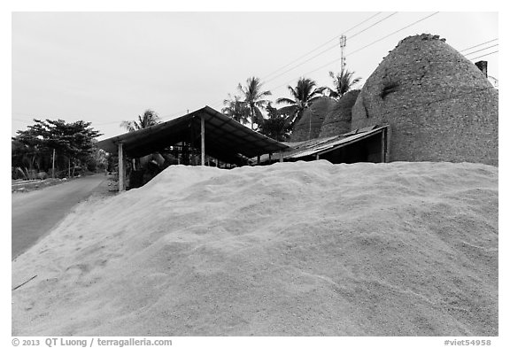 Pile of rice hulls near brick ovens. Mekong Delta, Vietnam (black and white)