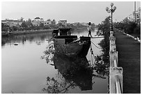 Woman in high heels walking out of barge. Tra Vinh, Vietnam (black and white)