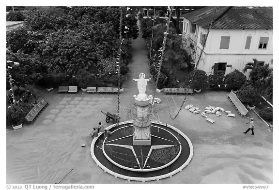 View of drying rice and statue from church tower. Tra Vinh, Vietnam