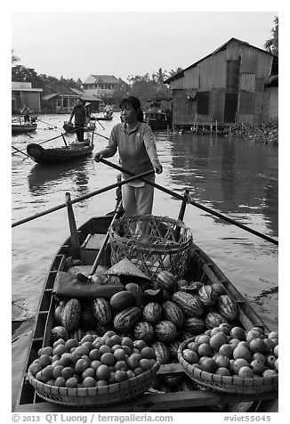 Woman paddles boat loaded with fruits and vegetable, Phung Diem. Can Tho, Vietnam (black and white)