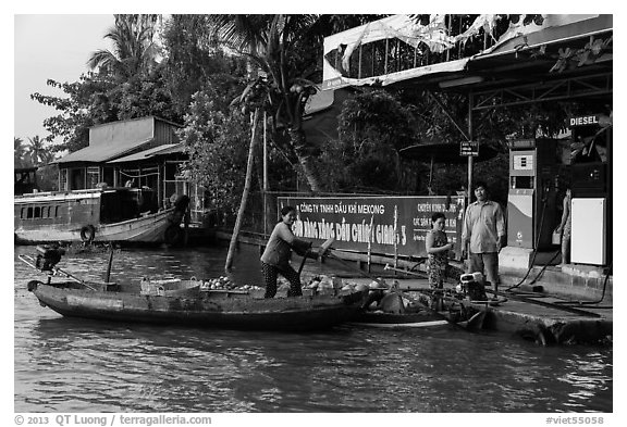 Women refilling boat tank. Can Tho, Vietnam (black and white)