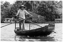 Woman using the distinctive x-shape paddle. Can Tho, Vietnam (black and white)