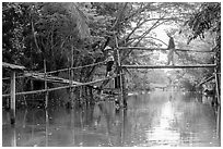 Villagers crossing monkey bridge. Can Tho, Vietnam (black and white)
