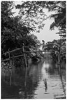 Woman walking across monkey bridge. Can Tho, Vietnam (black and white)