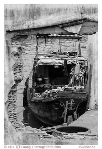 Boat loaded with bricks seen from brick wall opening. Can Tho, Vietnam (black and white)
