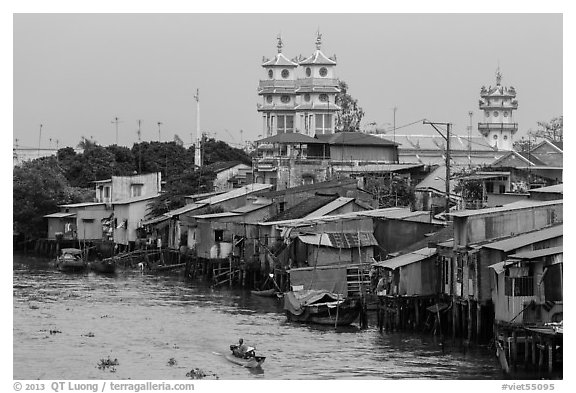 Riverside houses on stilts and Cao Dai temple. Mekong Delta, Vietnam
