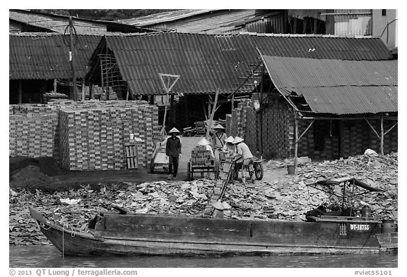 Workers loading bricks on boat. Sa Dec, Vietnam (black and white)