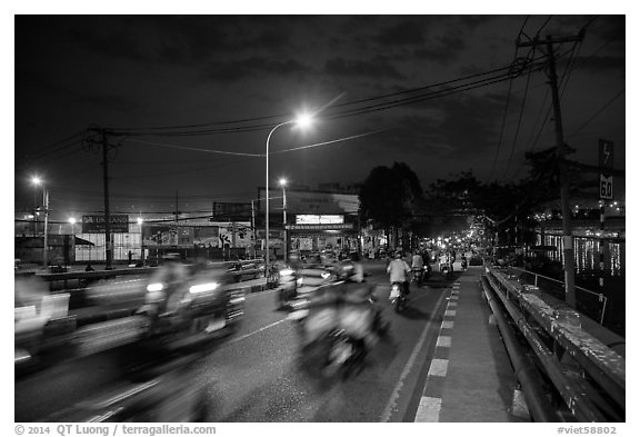Evening traffic by the canal, District 8. Ho Chi Minh City, Vietnam (black and white)