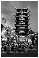 Worshippers and seven story  Quoc Tu pagoda at dusk. Ho Chi Minh City, Vietnam ( black and white)