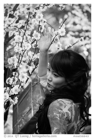 Woman next to Tet (Lunar New Year) decorations. Ho Chi Minh City, Vietnam (black and white)