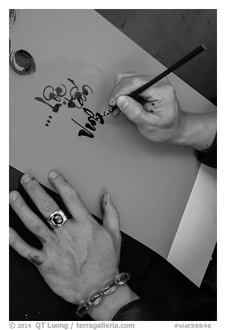 Hands drawing Tet greetings in ornamented characters. Ho Chi Minh City, Vietnam (black and white)