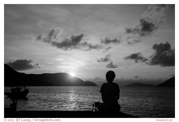 Sitting woman in silhouette and sunrise, Con Son. Con Dao Islands, Vietnam (black and white)