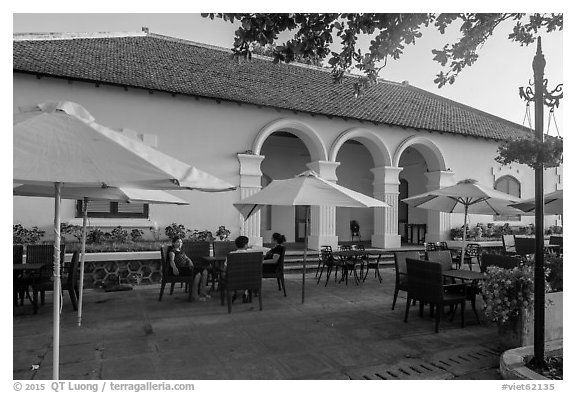 Patrons sitting on table in front of Con Son Cafe. Con Dao Islands, Vietnam (black and white)