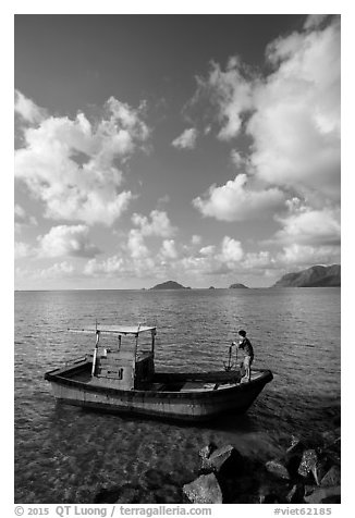 Fisherman lifting anchor from boat, Con Son. Con Dao Islands, Vietnam (black and white)