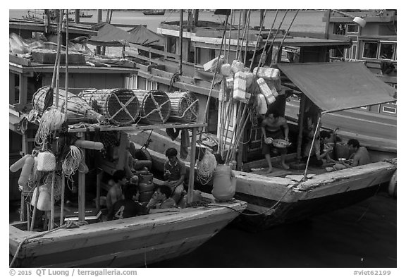 Sailors and families take lunch break at the back of boats, Ben Dam. Con Dao Islands, Vietnam (black and white)