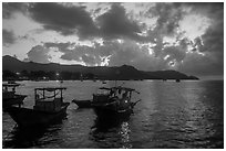Men with light on fishing boat at dawn, Con Son harbor. Con Dao Islands, Vietnam ( black and white)