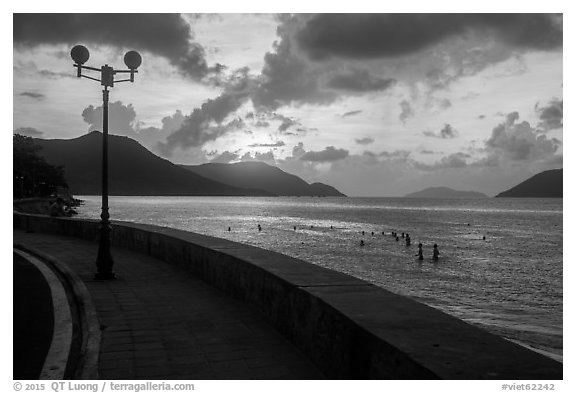 Seafront promenade and beachgoers at sunrise, Con Son. Con Dao Islands, Vietnam (black and white)