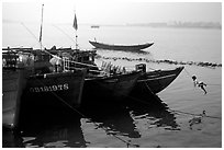 Children climbing aboard Fishing boat, Dong Hoi. Vietnam (black and white)