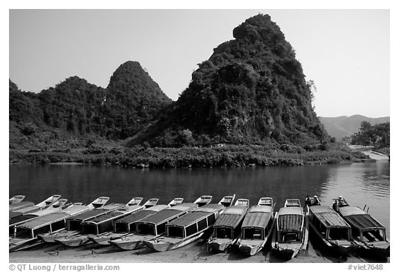 Tour boats and forest-covered limestone rocks, Son Trach. Vietnam (black and white)
