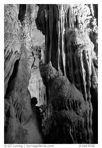 Tourist framed by cave formations, upper cave, Phong Nha Cave. Vietnam (black and white)