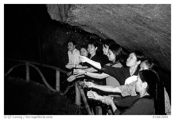 Women catch the water seeping from Tan Thanh Cave, said to have mirculous properties. Lang Son, Northest Vietnam (black and white)