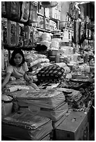 Vendor sitting amongst Abondance of cheap goods imported from nearby China at the Dong Kinh Market. Lang Son, Northest Vietnam (black and white)