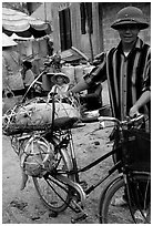 Man with a newly bought pig loaded on his bicycle, That Khe market. Northest Vietnam (black and white)