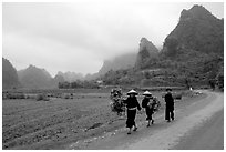 Villagers walking down the road with limestone peaks in the background, Ma Phuoc Pass area. Northeast Vietnam ( black and white)