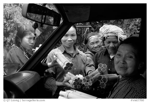 Peddlers offering sweet rice tubes for sale to traveler. Vietnam