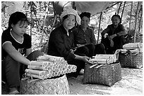 Women selling sweet rice cooked in bamboo tubes. Vietnam (black and white)