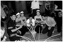 Thai women and guests drinking rau can alcohol with long straws, Ban Lac, Mai Chau. Northwest Vietnam ( black and white)