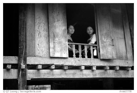 Two thai women at the window of their stilt house, Ban Lac village. Northwest Vietnam (black and white)